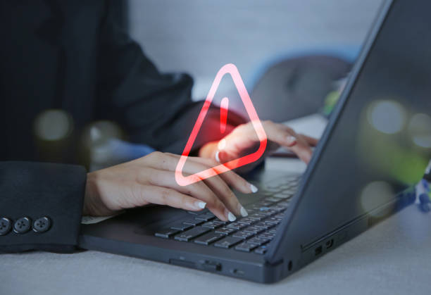istock Businesswoman using computer laptop with caution warning sign for notification error concept. 1475189418