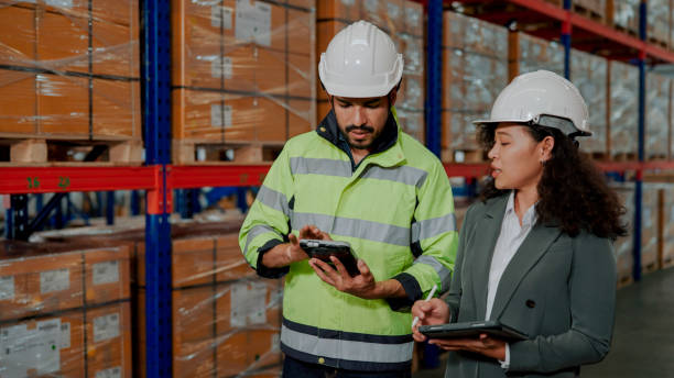 istock Male Warehouse Worker Answering Questions from Female Inspector. 1475192531