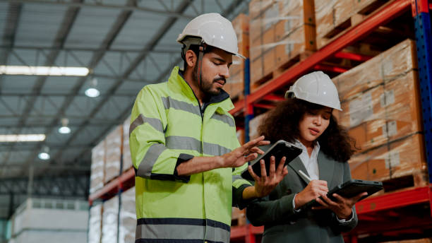 istock Male Warehouse Worker Explaining How Stocktaking Works in the Company He's Working in. 1475192533