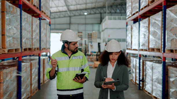 istock Male Worker Escorting Female Auditor on a Warehouse Inspection. 1475192546