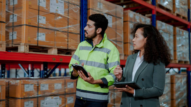 istock Male Warehouse Worker Answering Questions from Female Inspector. 1475192548