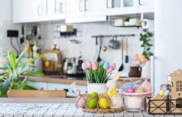 istock Easter decoration of colorful eggs in a basket and a rabbit on the kitchen table in a rustic style. Festive interior of a country house 1475198663