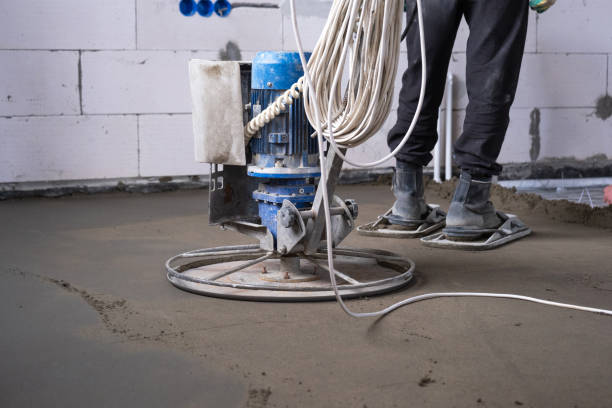 istock Ramming and grinding of semi-dry floor screed by a machine with a rotating disk for leveling. Construction of a concrete floor in the house, a master with special equipment. 1475198761