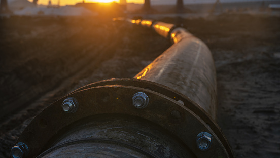 Metal pipeline in industrial area during sunset