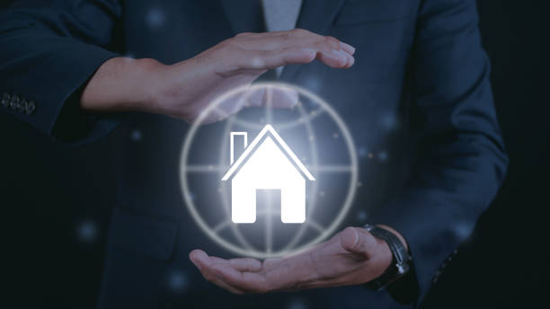 istock Businessman holding house icon. 1475200546