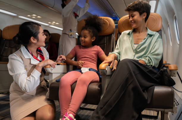 istock Airplane flight attendant providing service to kid and mother passengers on board. 1475201079
