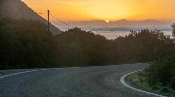 istock A paved, empty road in Corfu, Greece at sunset 1475203125