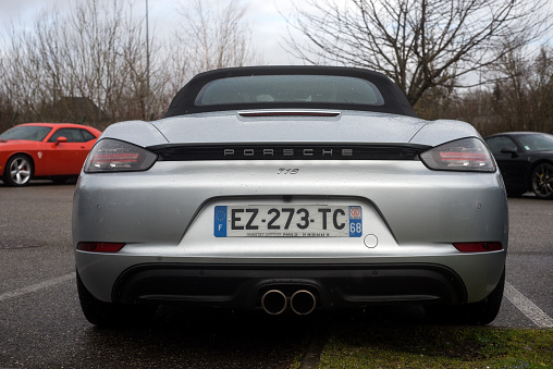 Mulhouse - France - 11 March 2023  - Rear view of grey Porsche 718 parked in the street by rainy day