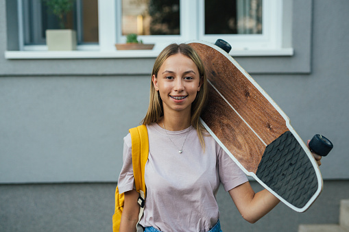teenager girl holding skateboard
