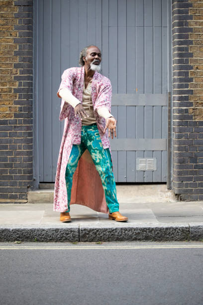 pria dewasa yang tidak konvensional menari di jalan dekat pintu gudang - london fashion potret stok, foto, & gambar bebas royalti