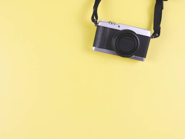 istock flat lay of digital camera on yellow  background with copy space. Photo and memory concept. 1475208612