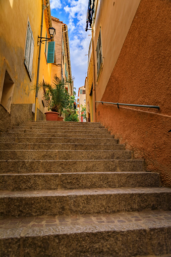 Stairs on a narrow street between traditional old terracotta houses in the Old Town of Villefranche sur Mer on the French Riviera, South of France