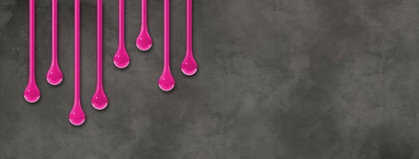 istock Pink ink drops on dark concrete wall. Horizontal banner 1475210427