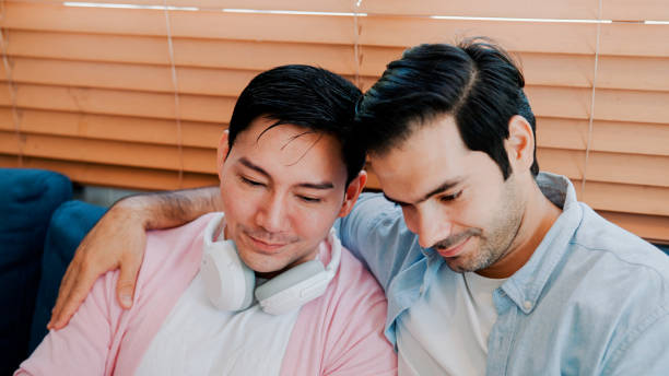 istock Young Male Lovers Cuddling with Each Other While Ordering Online Products via Digital Tablet. 1475211770