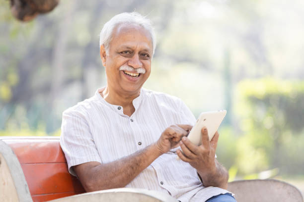 istock Happy senior men using digital tablet at park 1475212424