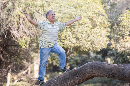 Senior man trying to climbing on the tree