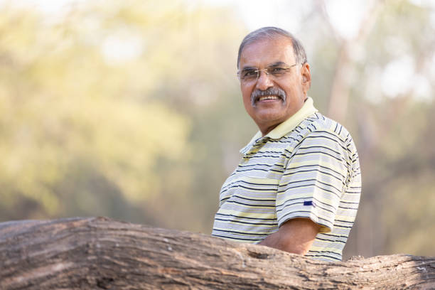 Senior man with arms crossed at park