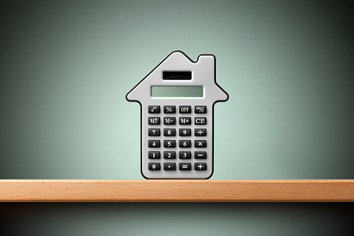 Mortgage calculator. Calculator in form of house on the shelf.