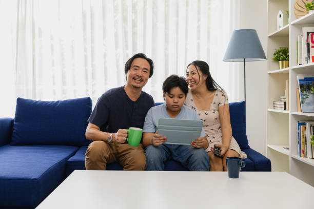 istock Family watching tv at home, boy using tablet. 1475217067