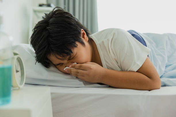 istock Sick asian boy at home, sneezing. 1475218285