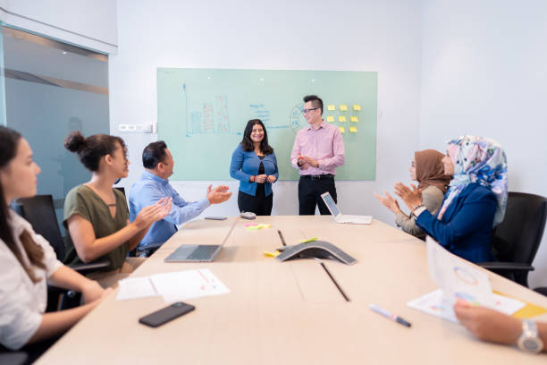 istock businesspeople applauding  sitting in the boardroom 1475218345