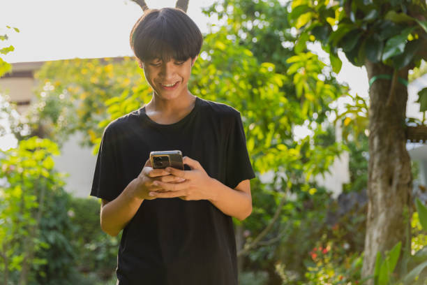 istock Teenage boy using mobile phone at outdoor. 1475218495