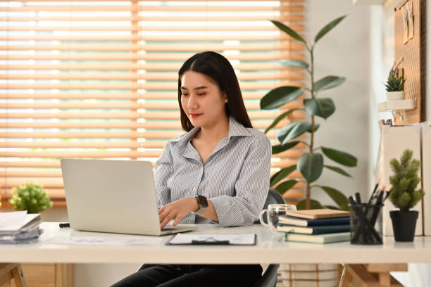 istock Beautiful female entrepreneur watching online presentation on laptop computer at modern office. 1475218856
