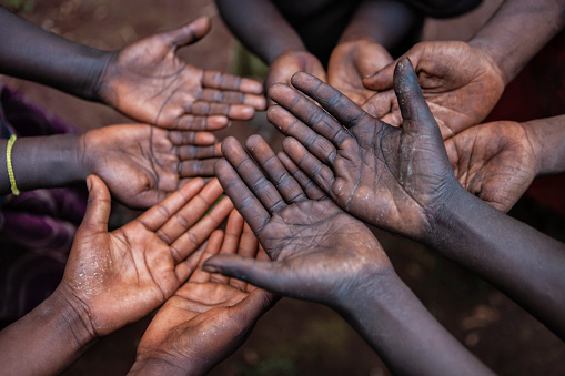 Poor African children keeping their hands up - asking for food. Many African children suffer from poverty - 20% of Africa’s children will die before the age of five.  Every day 30,000 children die from a combination of disease- infested water and malnutrition.