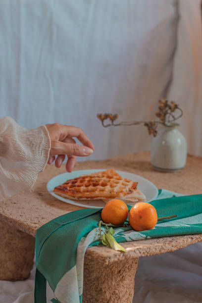 istock Vertical shot of a woman's hand taking a waffle from a plate 1475220176