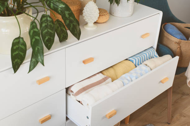 istock white drawer with stack of warm cozy sweaters. Spring home cleaning. Wardrobe organization, lifestyle, comfy home. 1475220899