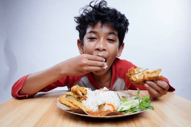 istock Child having Fried Chicken and rice for lunch 1475221036