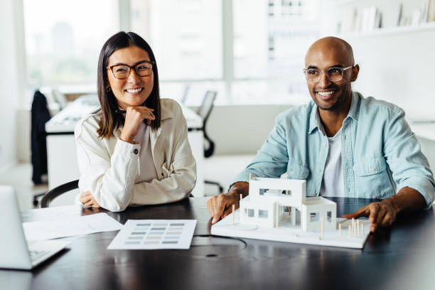 istock Two architects working with a 3D house model in an office 1475221682