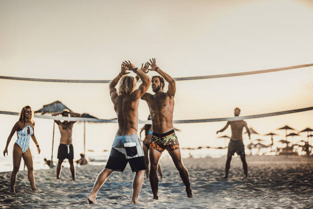cheerful men celebrating victory in beach volleyball. - volleyball beach volleyball beach sport imagens e fotografias de stock