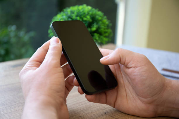 istock male hands hold phone with black screen background cafe 1475222933