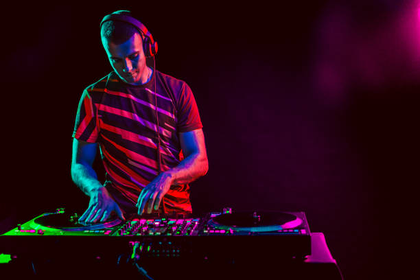 Male DJ playing music in the night club stock photo
