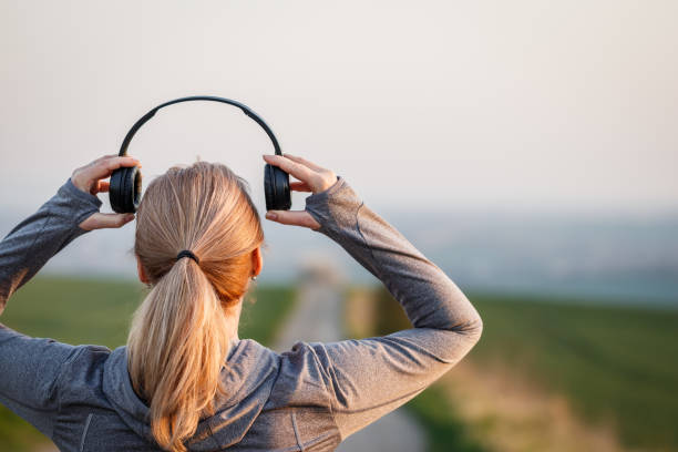istock Woman with headphones getting ready for running on road 1475226774