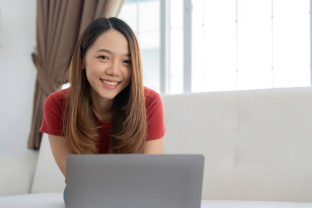 istock An attractive young woman is working on a laptop while sitting on sofa at home 1475227233