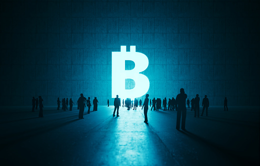 Human crowd waiting before glowing Bitcoin symbol on concrete wall. Horizontal composition with copy space.
