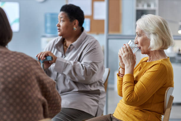 Senior woman sitting in circle at mental health support group