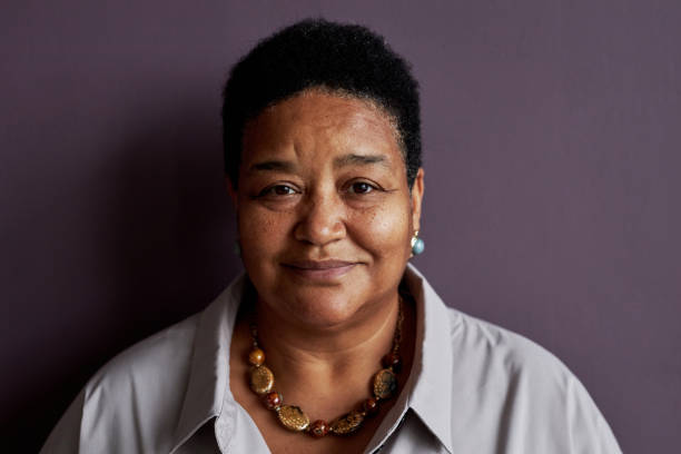istock Front senior black woman smiling at camera against purple background 1475231248