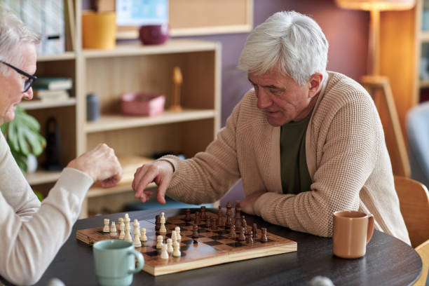 istock White haired senior man playing chess at table in retirement home 1475231265