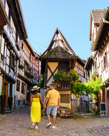 A couple of men and women on vacation in Eguisheim France Beautiful view of the colorful romantic city of Eguisheim near Colmar during summer