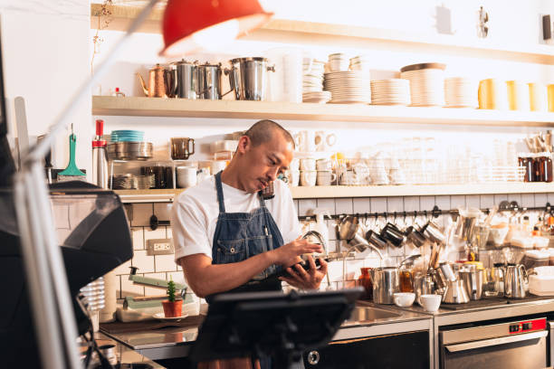 istock Coffee shop owner check stock by phone and tablet 1475231510