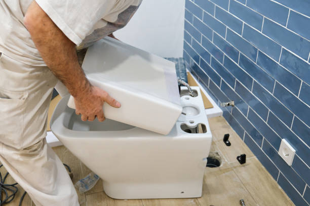 istock Unrecognizable senior plumber installer installing toilet cistern. 1475231617