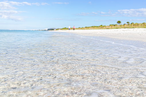 Crystal clear transparent blue water of Gulf of Mexico at Barefoot Beach, Southwest Florida near Bonita Springs and blurry background on sunny day