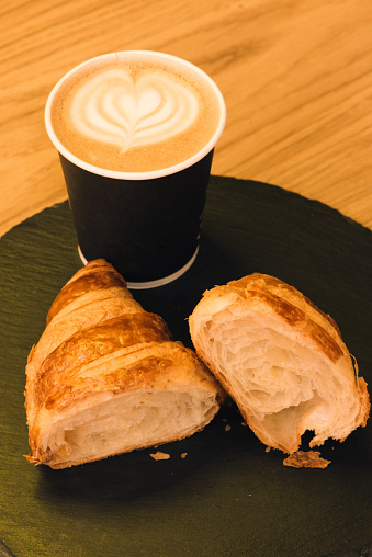 Paper coffee cup with croissant