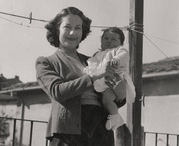 istock Mother and daughter on balcony, 1949. 1475234511