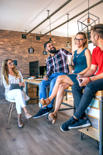 Work team laughing sitting over the table on coworking