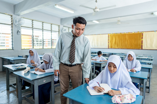 Teacher in the classroom attending an elementary class