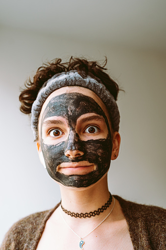 Close-up face young girl in black cosmetic mask, with brown eyes, bandage on hair, choker around neck, with an emotion on face